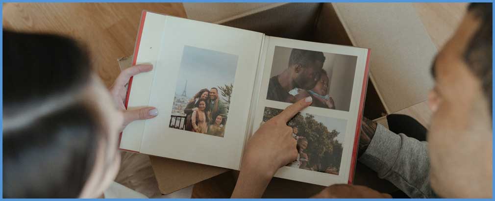 Two people look at a photo album.