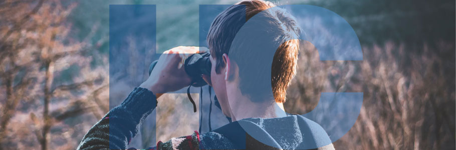 Man using binoculars in the countryside.