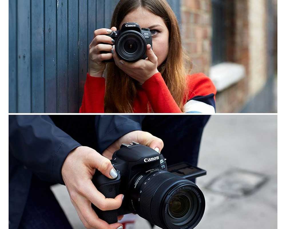 A woman points the Canon EOS 77D to the camera as if taking a picture.