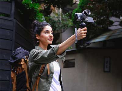 Woman using the camera with a stabiliser.