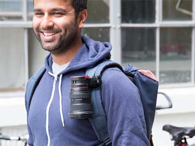 Man using the Peak Design Lens Kit on his bag strap.